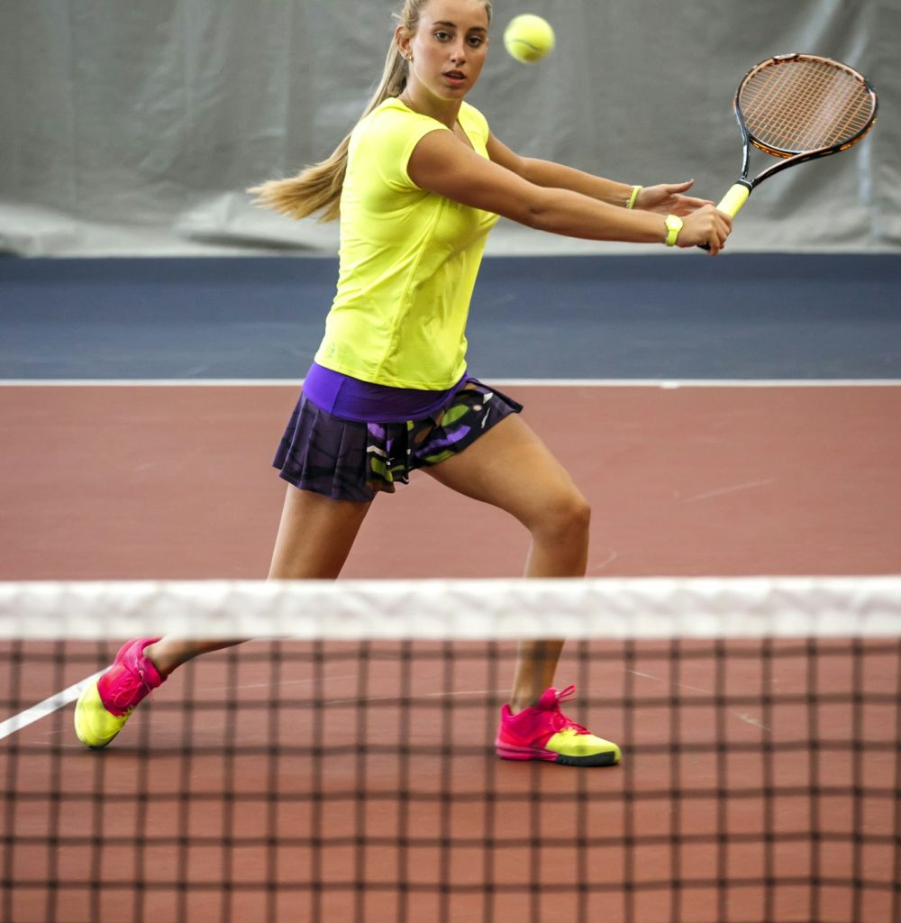 Young woman playing tennis in an indoor tennis center